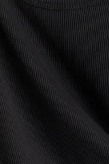 Musculosa en punto acanalado negro, de corte entallado con escote en U pronunciado tanto en el frente como en la espalda.