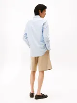 Camisa celeste de algodón regenerativo con tejido de sarga, corte regular, cuello camisero clásico, cierre con botones, puños abotonados y logo de Tommy Hilfiger bordado en el pecho.