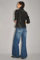 Jean de corte palazzo con tiro alto y pierna ancha, confeccionado en denim de lavado azul oscuro con efecto desgastado.