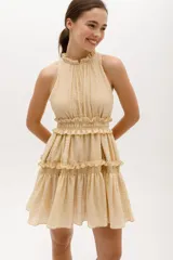 Vestido corto color salmón, con escote halter con volados y falda escalonada con volados.