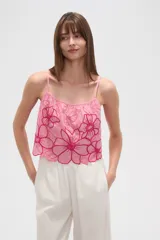 Top lencero de algodón color rosa claro, con tirantes finos y escote profundo. Presenta bordados florales grandes en color fucsia con detalles de mostacillas en el centro de las flores. El calce es holgado.