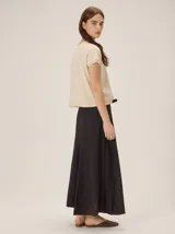 Falda midi negra de poliéster, con diseño fluido y ligero, ideal para la temporada de verano.
