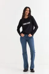 Remera de manga larga color beige con cuello redondo a la base. Presenta un estampado frontal con un dibujo de labios en color fucsia y la palabra 'BESITO' en color negro.