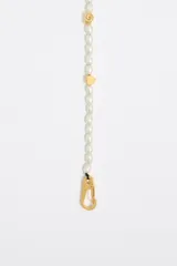 Collar corto de perlas cultivadas con dijes dorados de diferentes formas: corazón, pez, estrella, letra G y logo de la marca. Cierre de mosquetón dorado.