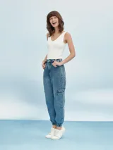 Pantalón jean de corte relaxed, con diseño cargo, cintura elástica con cordón ajustable y puños elastizados en los tobillos. Presenta bolsillos laterales en las piernas y bolsillos traseros.