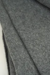 Poncho gris liso con flecos largos en el borde superior.