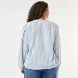 Blusa de corte fluido con estampado de rayas verticales finas en tonos azul y rojo. Presenta cuello redondo con abertura frontal y cordones con borlas, mangas largas abullonadas con puños elásticos y un diseño holgado.