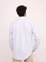 Camisa de corte regular confeccionada en tejido Oxford de algodón, con diseño de rayas verticales finas. Presenta cuello abotonado, cierre frontal con botones y un bolsillo en el pecho.