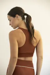 Top deportivo color ladrillo, de lycra reciclada, con espalda nadadora y faja inferior.