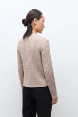 Cardigan de punto con textura de ochos, color tostado melange, con cuello redondo y cierre frontal de botones.