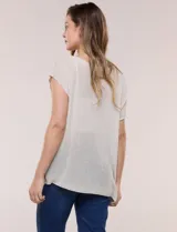 Blusa negra de tejido de punto fino con hilos de lúrex brillante, escote redondo amplio, mangas cortas con hombros caídos y silueta semi holgada.
