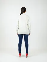 Buzo de punto en color beige, con cuello alto, mangas largas y terminaciones acanaladas en puños y ruedo.