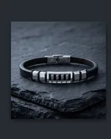 Pulsera masculina con banda de caucho negro y eslabones centrales de acero inoxidable con diseño geométrico grabado.