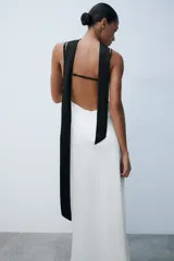 Vestido largo lencero con diseño bicolor en blanco y negro, escote en pico, tirantes finos ajustables, espalda descubierta y foulard incorporado a contraste.