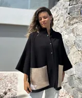 Saco tejido de punto en color negro, con corte holgado y mangas tres cuartos. Presenta bolsillos frontales amplios confeccionados en cuero metalizado color plateado y cierre frontal con botones.