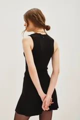 Top sin mangas con cuello halter, confeccionado en tejido de punto con acabado metalizado. Presenta un ajuste al cuerpo y diseño minimalista.