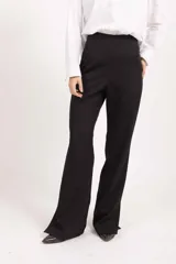 Pantalón sastrero de tiro alto y corte recto con caída amplia, confeccionado en tela de sastre color negro.
