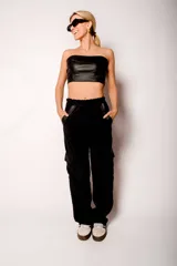 Pantalón cargo de pana negro con bolsillos laterales con solapa y cintura elástica.