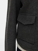 Campera estilo biker corta de punto interlock, con cuello camisero, cierre frontal metálico y bolsillos delanteros con solapa y broches a presión. Presenta un diseño liviano sin forrería y mangas largas.