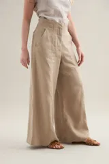 Pantalon largo de lino color tostado, tiro alto, corte ancho y recto, con costuras centrales decorativas y bolsillos laterales.