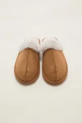 Pantuflas cerradas color marrón con ribetes de piel sintética en la abertura y suela plana.