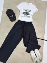 Pantalón de estilo deportivo confeccionado en tela con friza, de corte ancho y tiro medio con cintura elástica y cordón de ajuste.