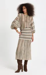 Blusa de punto con rayas verticales en tonos marrón, beige, verde y blanco, corte amplio, escote redondo y mangas largas anchas con puños ajustados.