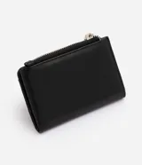 Billetera femenina Satinato tipo sobre, confeccionada en PU color negro con estructura firme, cierre con botón a presión, bolsillo externo con cierre metálico, compartimentos internos y placa metálica frontal con logo.