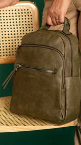 Mochila urbana color beige de símil cuero, con dos bolsillos frontales, bolsillo principal de gran capacidad con dos bolsillos internos con cierre y uno abierto, bolsillos laterales abiertos, asa de mano y correas regulables en galón.