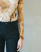 Body de tul ajustado con estampado animal print, escote redondo y mangas largas.