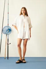 Camisa de corte oversize y diseño holgado, confeccionada en tela de viscosa texturizada. Presenta cuello clásico, cierre frontal con botones de carey y mangas cortas con dobladillo.