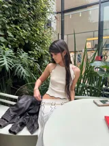 Conjunto de top y pollera color crema con ribetes negros. El top es musculosa con cuello redondo y la pollera es larga con estampado abstracto.