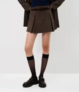 Short pollera de corte sastrero con estampado a cuadros, diseño con pliegues frontales, cintura estructurada con pasadores y cinturón incluido.