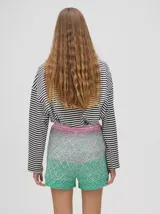 Short de punto tejido con patrón de rombos en tonos degradados de celeste y amarillo. Presenta una pretina elástica y un calce suelto.
