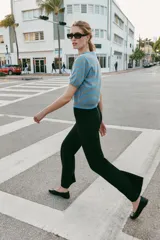 Jersey de punto con cuello redondo y manga corta, confeccionado en lana 100%. Presenta un patrón de rayas horizontales alternando azul celeste y marrón claro.