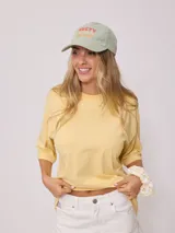 Gorro de visera color lila, estilo dad hat, de lona lavada con bordado frontal en blanco que dice "RUSTY AUSTRALIA MERMAID BEACH".