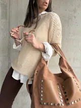 Buzo color beige de hilo con mangas largas y detalle de calado en los hombros.