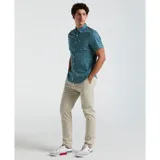 Camisa de hombre de manga corta con estampado geométrico en tonos azul, celeste, blanco y negro. Tiene cuello clásico, cierre con botones y bolsillo en el pecho.