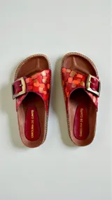 Sandalias de cuero modelo Kiri de la línea Ottenta, color rojo con diseño pintado a mano, una tira ancha con hebilla metálica grande y plantilla anatómica.