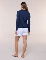 Campera liviana blanca de silueta entallada con protección solar UPF 50, cuello alto y cierre frontal completo. Cuenta con mangas largas y bolsillos laterales.