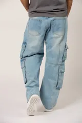 Jean baggy cargo de color celeste claro, de corte amplio y relajado, con múltiples bolsillos utilitarios en los laterales de las piernas.
