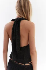 Top bordó de punto con lurex, escote en V profundo estilo halter y diseño sin mangas.