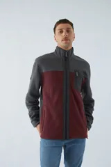 Campera polar para hombre de corte recto, con cuello alto, cierre frontal completo, bolsillos laterales con cierre y logo estampado en el pecho.