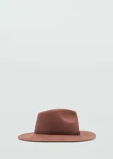 Sombrero tipo fedora de ala ancha, confeccionado en lana color marrón, con cinta decorativa de cuero sintético a tono en la base de la copa.