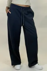 Pantalon deportivo de corte recto y tiro medio, confeccionado en tejido de algodón con cintura elástica y cordón ajustable. Presenta un diseño holgado y cómodo.