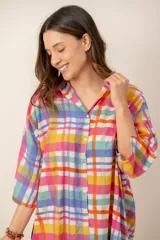 Vestido corto camisero con estampado de rayas multicolores, cuello camisero, mangas tres cuartos y cierre frontal de botones.