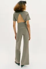 Pantalón largo negro de tiro alto, confeccionado en tejido elástico, con cintura elástica y diseño de pierna ancha tipo palazzo con bajo evasé.