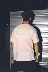 Remera color salmón de corte oversize, con estampa en la espalda con el logo de la marca y horario de delivery.