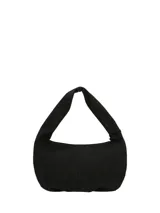 Cartera hobo de cuero sintético negro de la marca Hush Puppies, modelo Taffy. Presenta un diseño suave con una correa ancha para el hombro y detalles de tachas metálicas redondas a lo largo de los bordes laterales e inferiores. Incluye un llavero colgante con la silueta del perro basset hound característico de la marca y el logo impreso en la parte frontal.