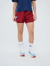 Short deportivo Umbro del Club Nacional de Football, modelo Luli para mujer, de color bordó con diseño de doble capa y cintura elástica con cordón de ajuste. Incluye el escudo del club bordado en la pierna derecha.